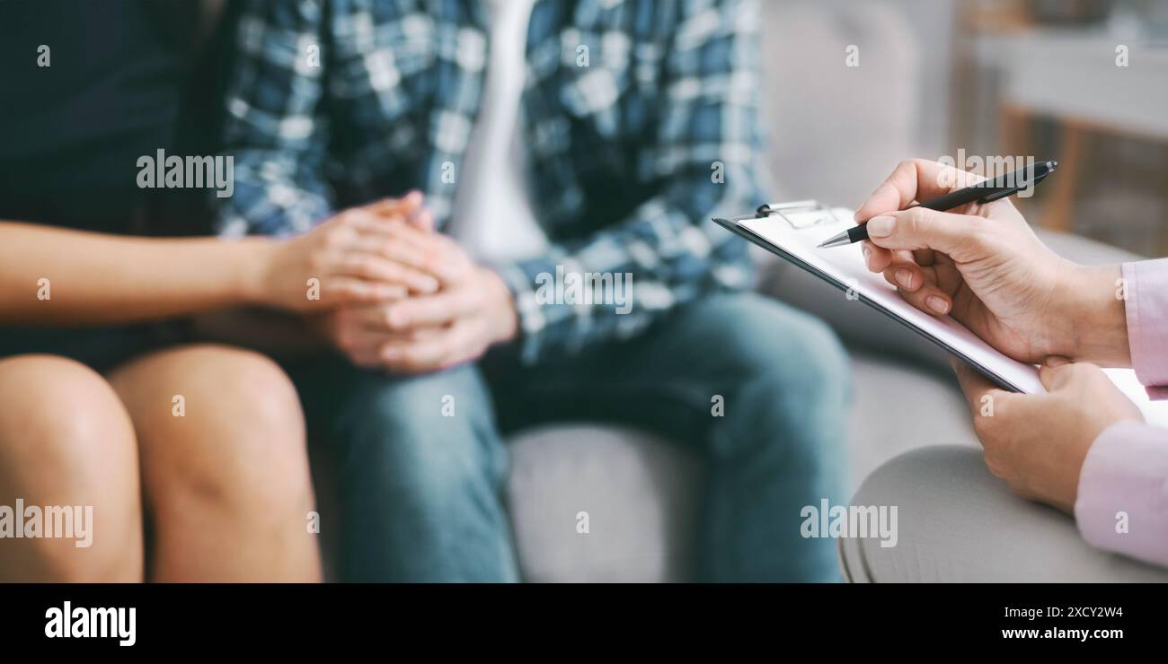 Therapist Taking Notes While Couple Sits Together In Counseling Session Stock Photo