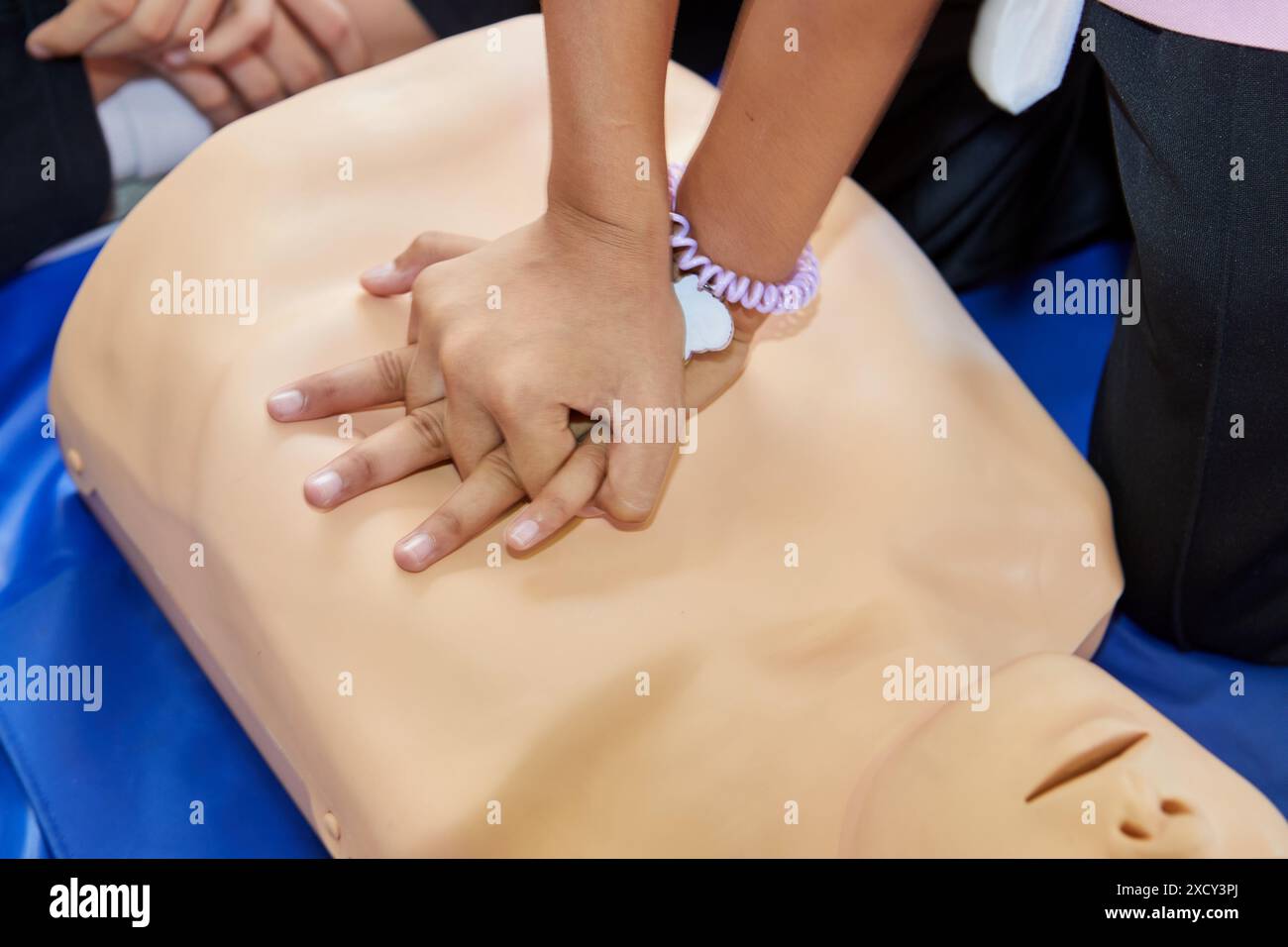 Cropped hands CPR First Aid training with CPR dummy in the classroom Stock Photo