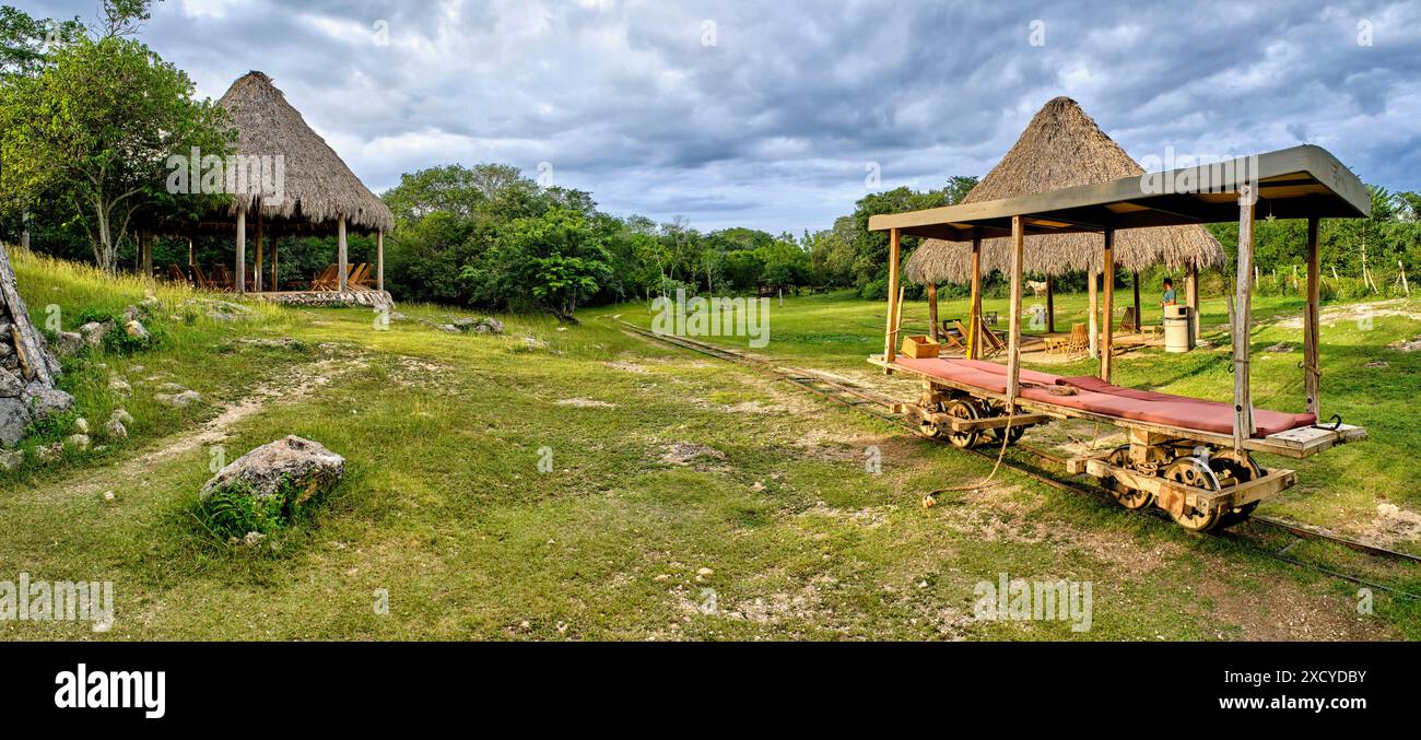 Thatched gazebos and old railroad cart at Sotuta de Peon Hacienda Viva, Yucatan, Mexico Stock Photo