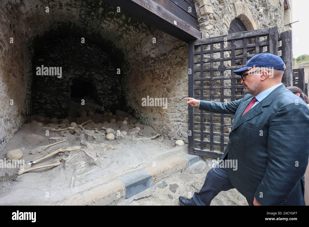 Ercolano, Italy, 19 June 2024. The Minister of Culture, Gennaro Sangiuliano, looks at he skeletons of the victims of the eruption of 79 AD, during the inauguration of the ancient beach inside the archaeological excavations of Ercolano, open to the public for the first time. Stock Photo