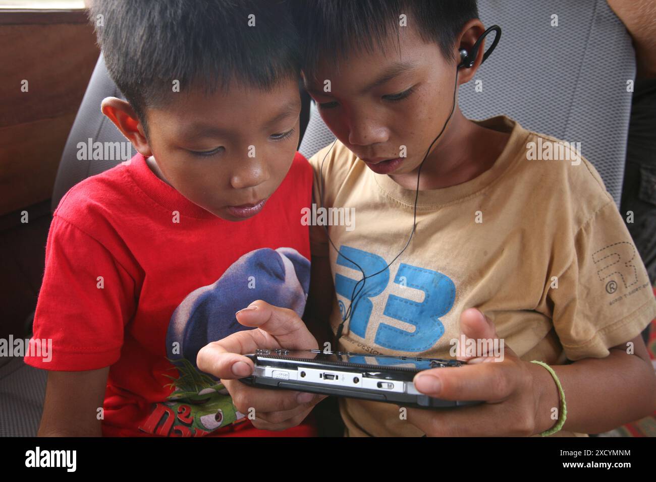 Laos, Luang Prabang. Two boys play a computergame. Stock Photo
