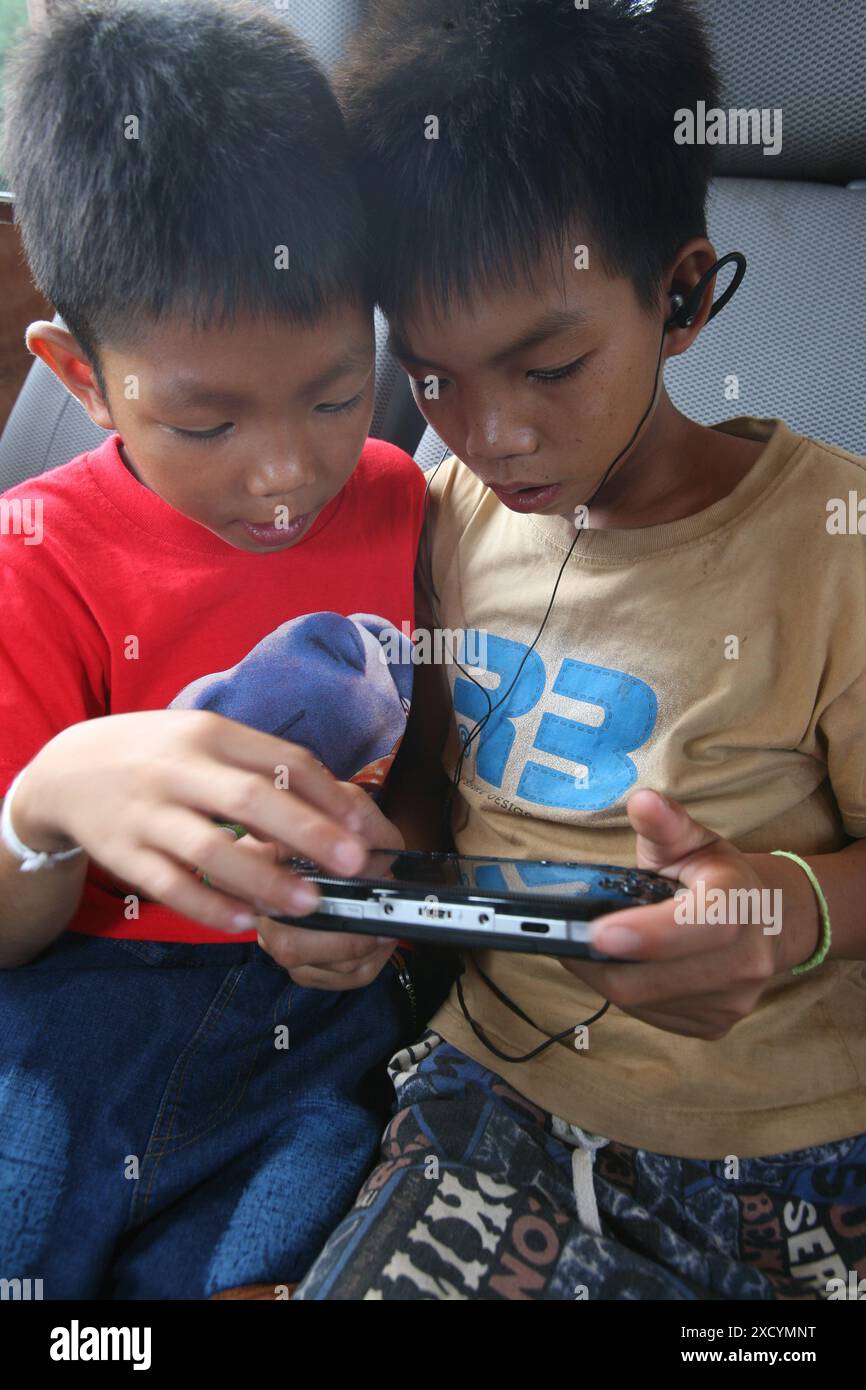 Laos, Luang Prabang. Two boys play a computergame. Stock Photo