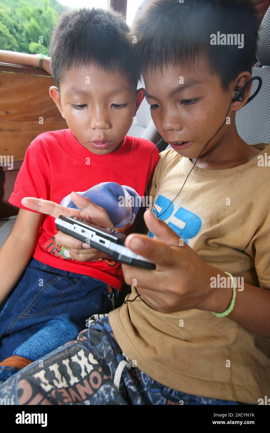 Laos, Luang Prabang. Two boys play a computergame. Stock Photo