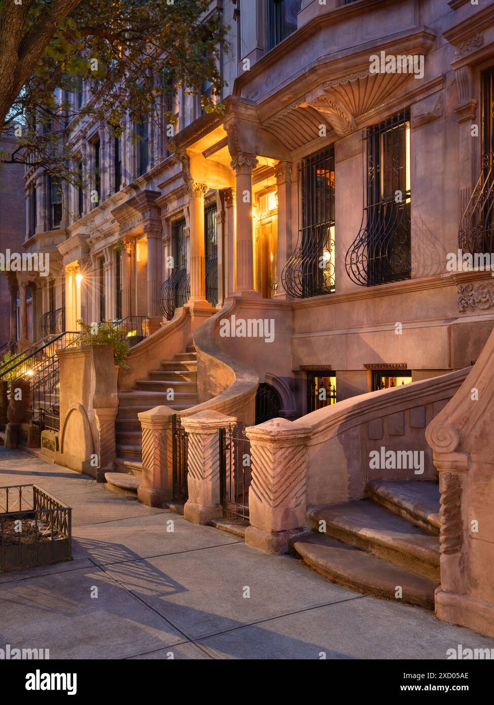 Evening view of iconic brownstones with stoop steps in New York City's Harlem, Manhattan (Mount Morris Historic District) Stock Photo