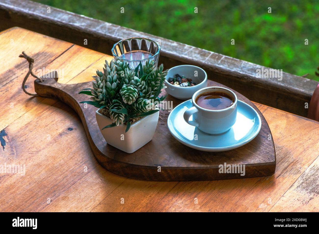 Elegant presentation of Turkish coffee with water and pebble chocolate set in a tranquil natural environment, offering a serene and picturesque experi Stock Photo