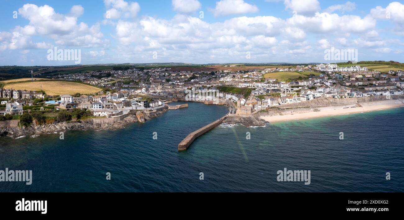 Aerial landscape of the quaint Cornish fishing town of Porthleven in Cornwall with rocky coastline and white sandy beach with harbour wall which is a Stock Photo