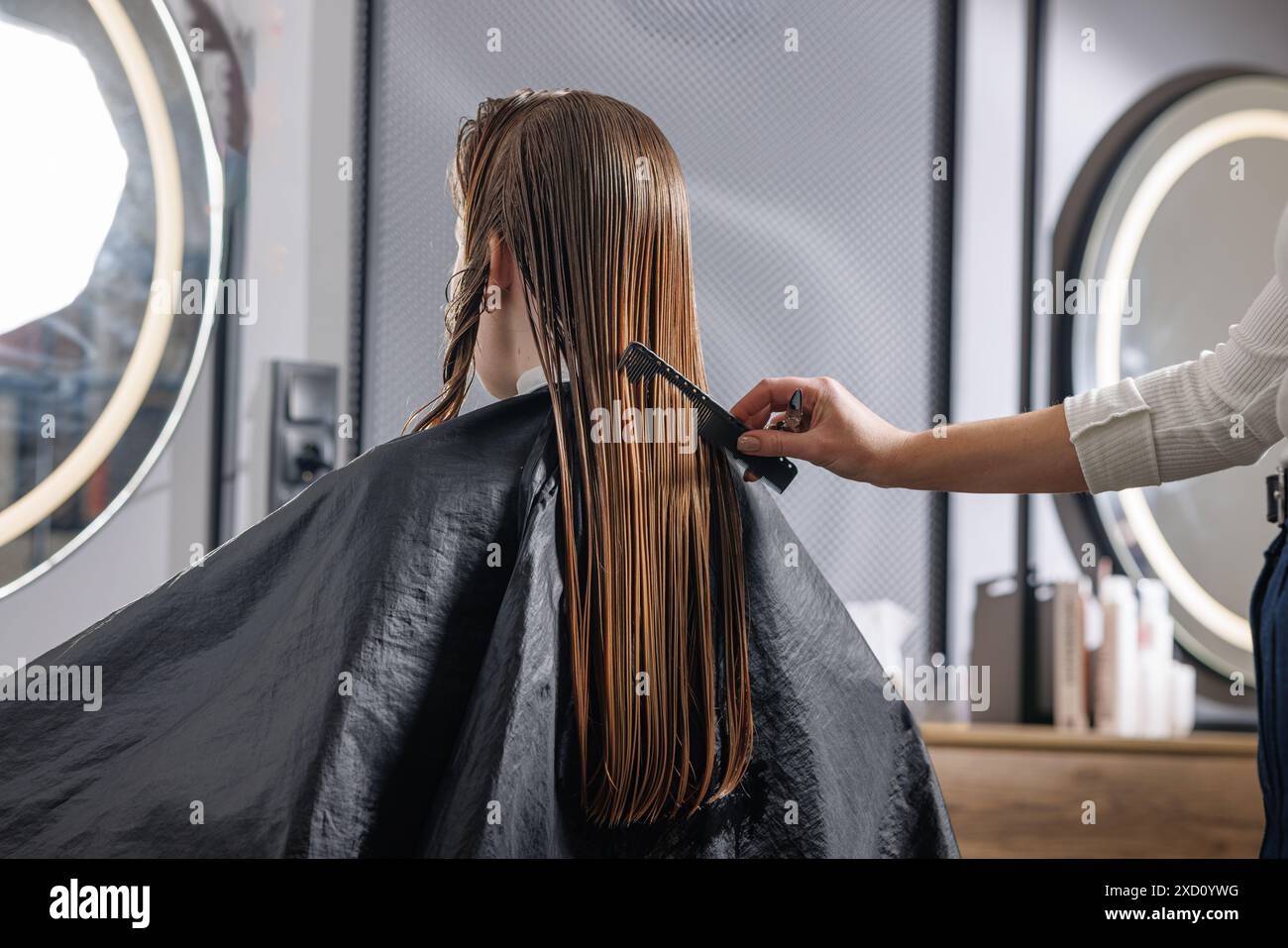 beauty master combing client's wet hair in beauty salon close-up, self-care concept, professional hair care Stock Photo