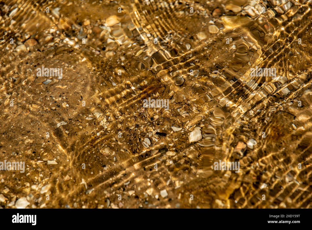 patterns in the sand painted by the rippling water Stock Photo