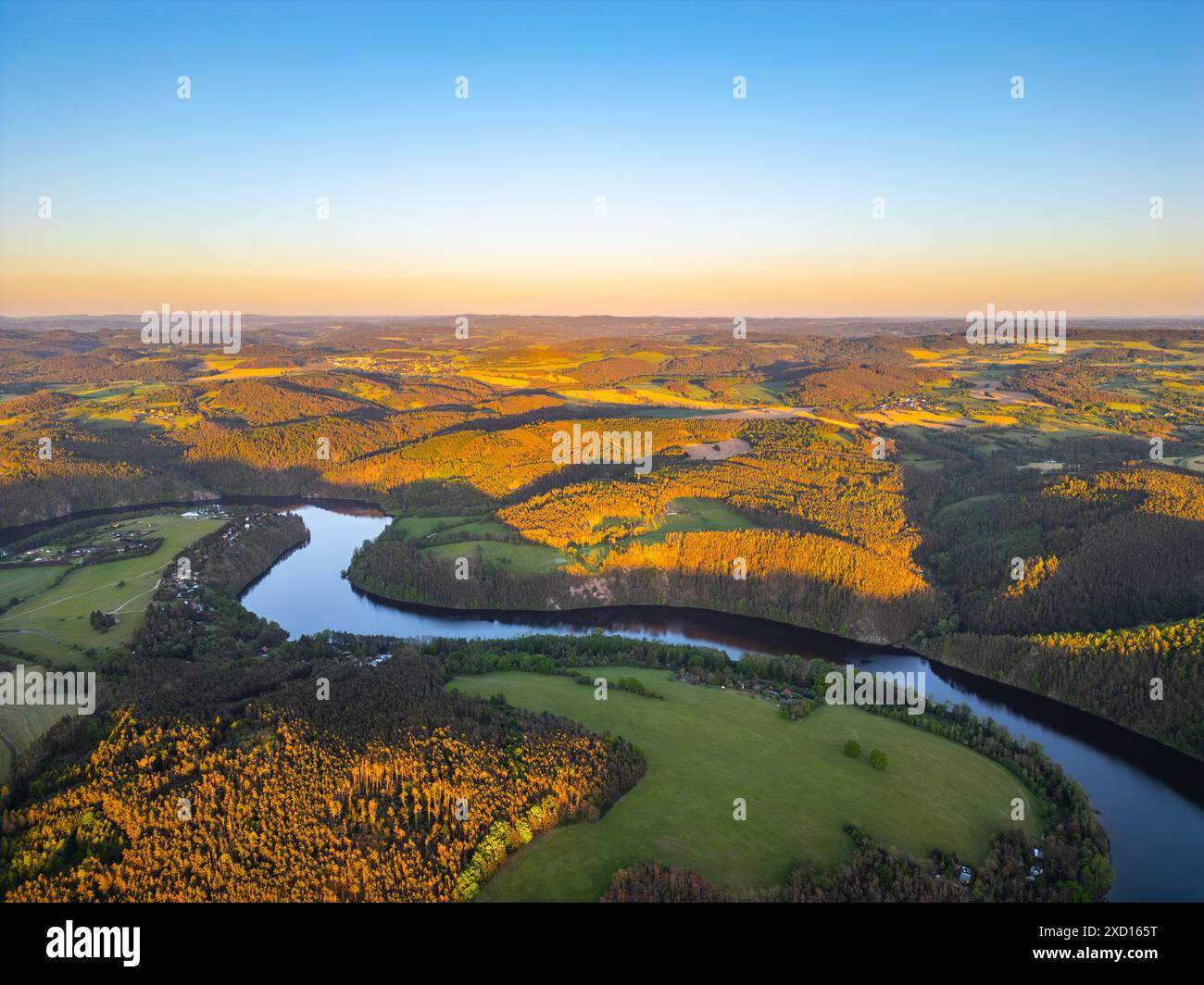 An aerial view of the Vltava River winding through the rolling hills of ...