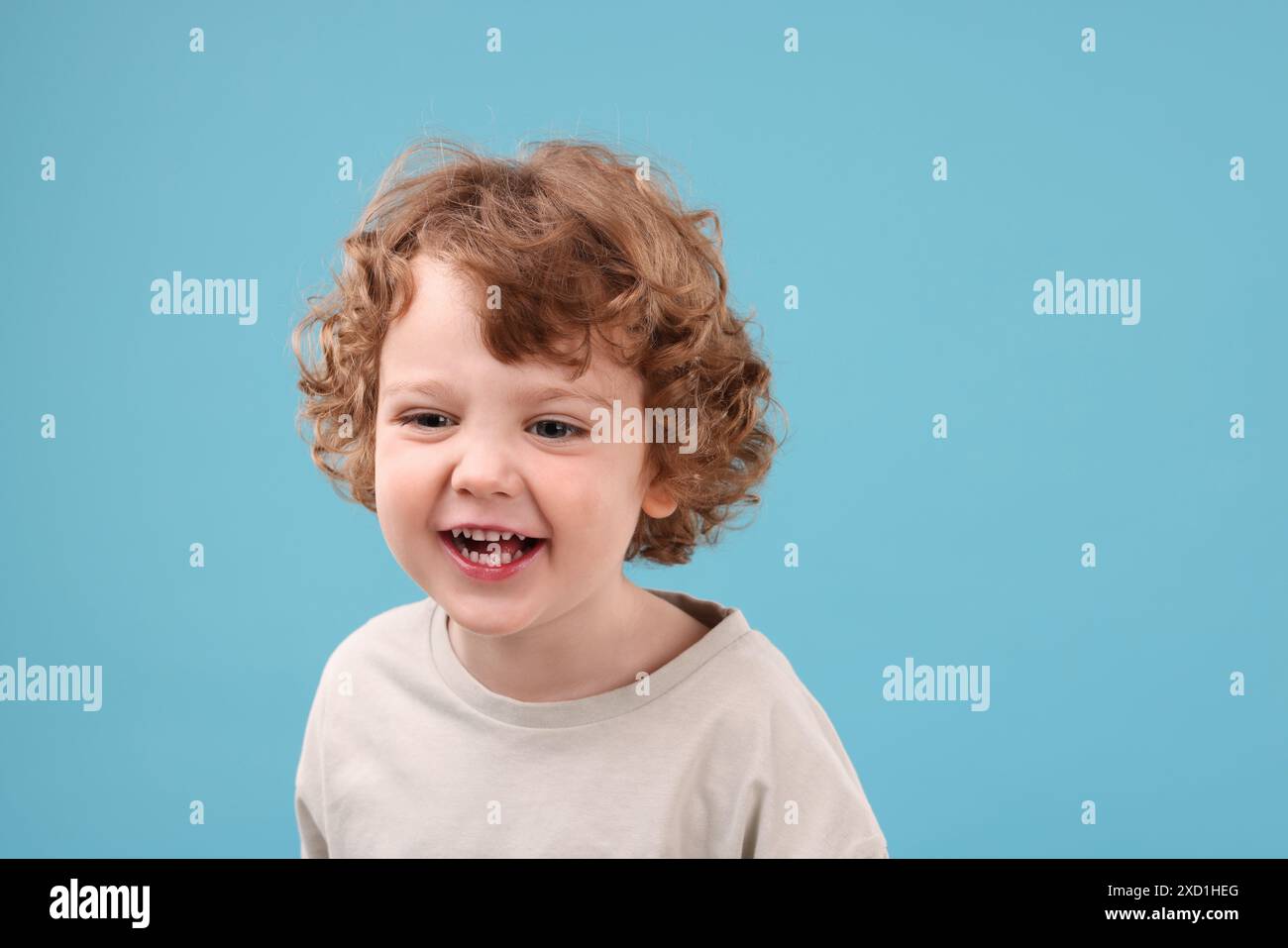 Portrait of cute little boy on light blue background Stock Photo - Alamy