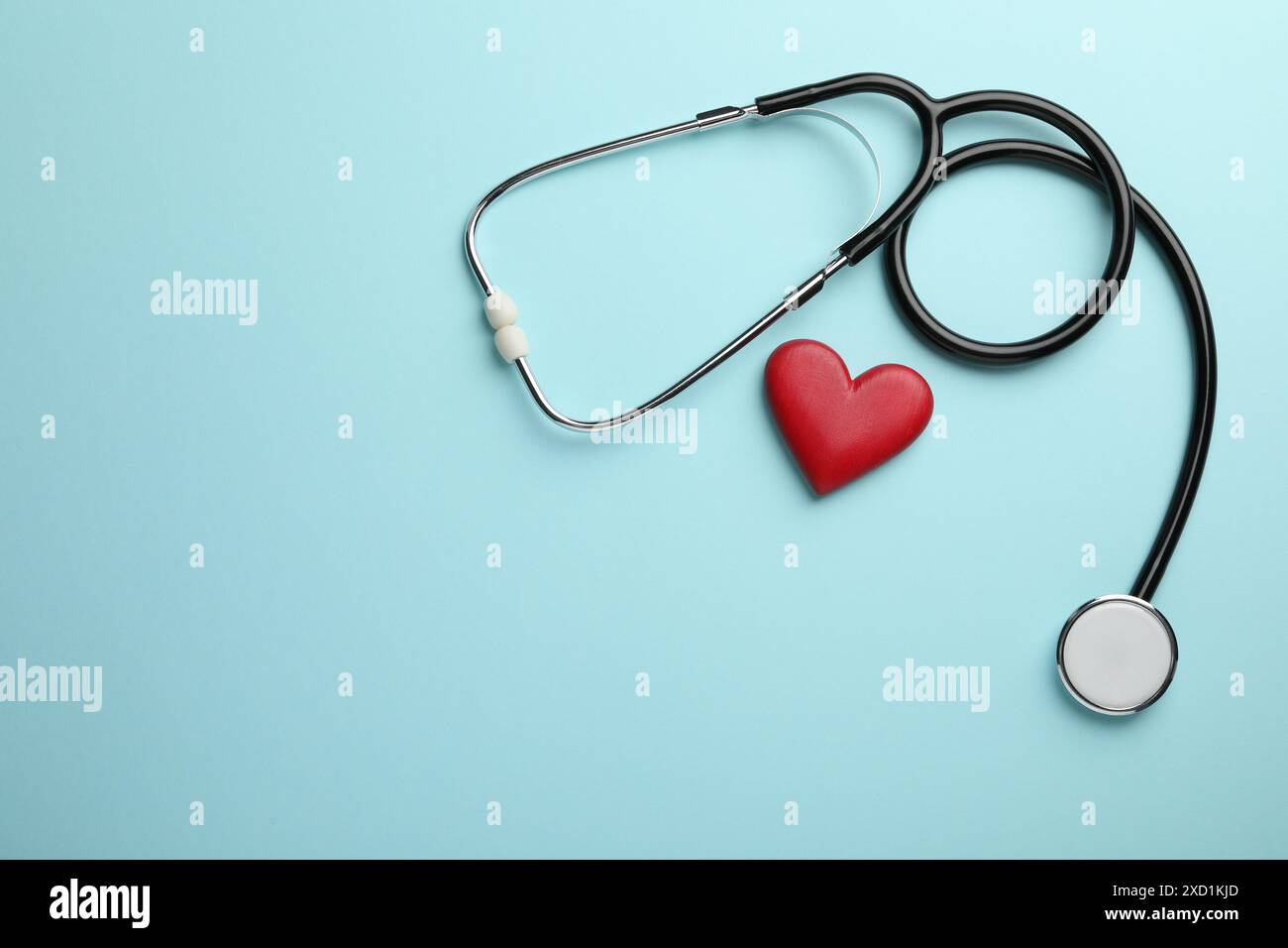 Stethoscope and red heart on light blue background, top view. Space for ...