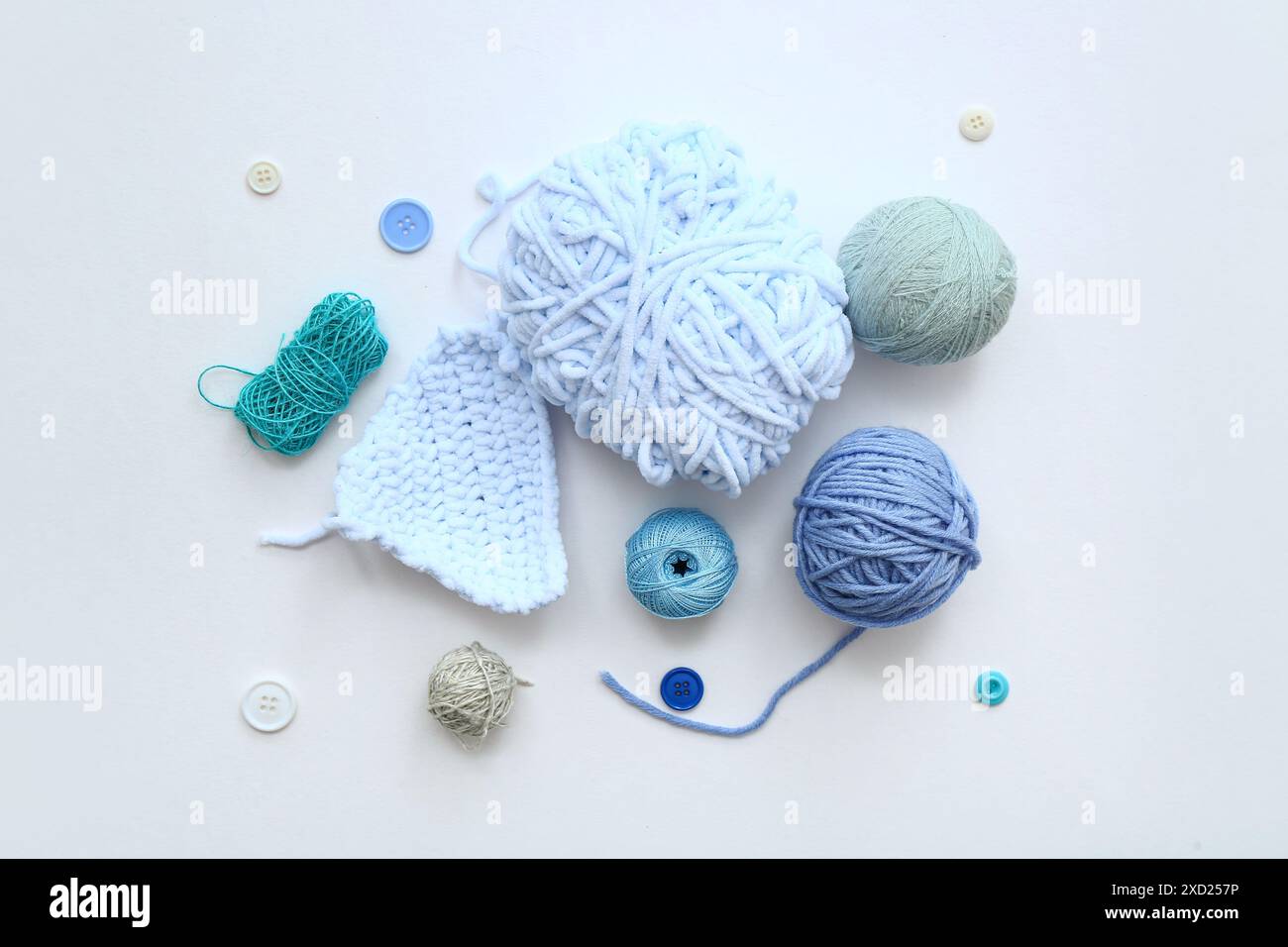 Yarn balls and buttons on white background Stock Photo