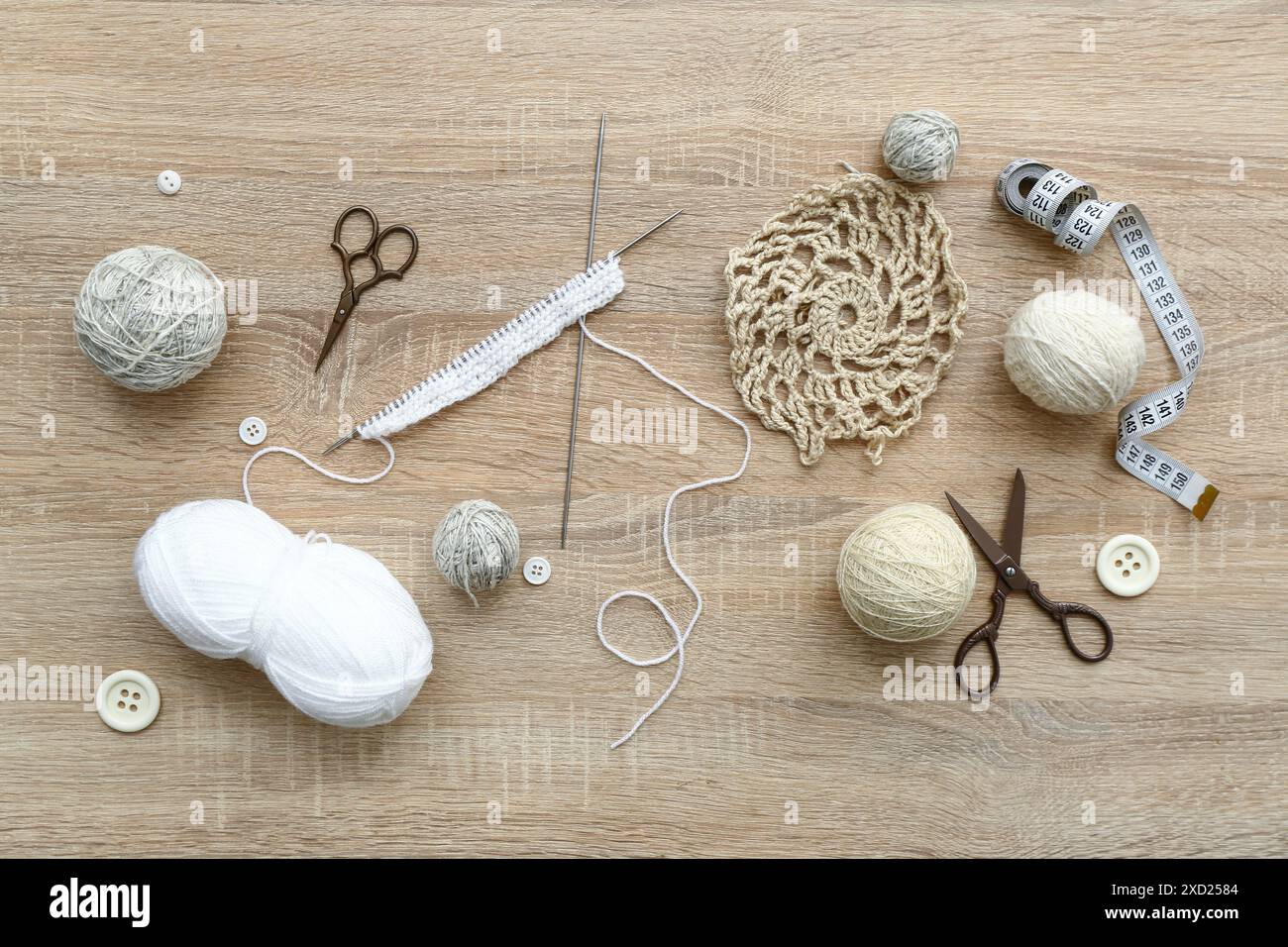 Yarn balls, scissors and knitting accessories on wooden background Stock Photo