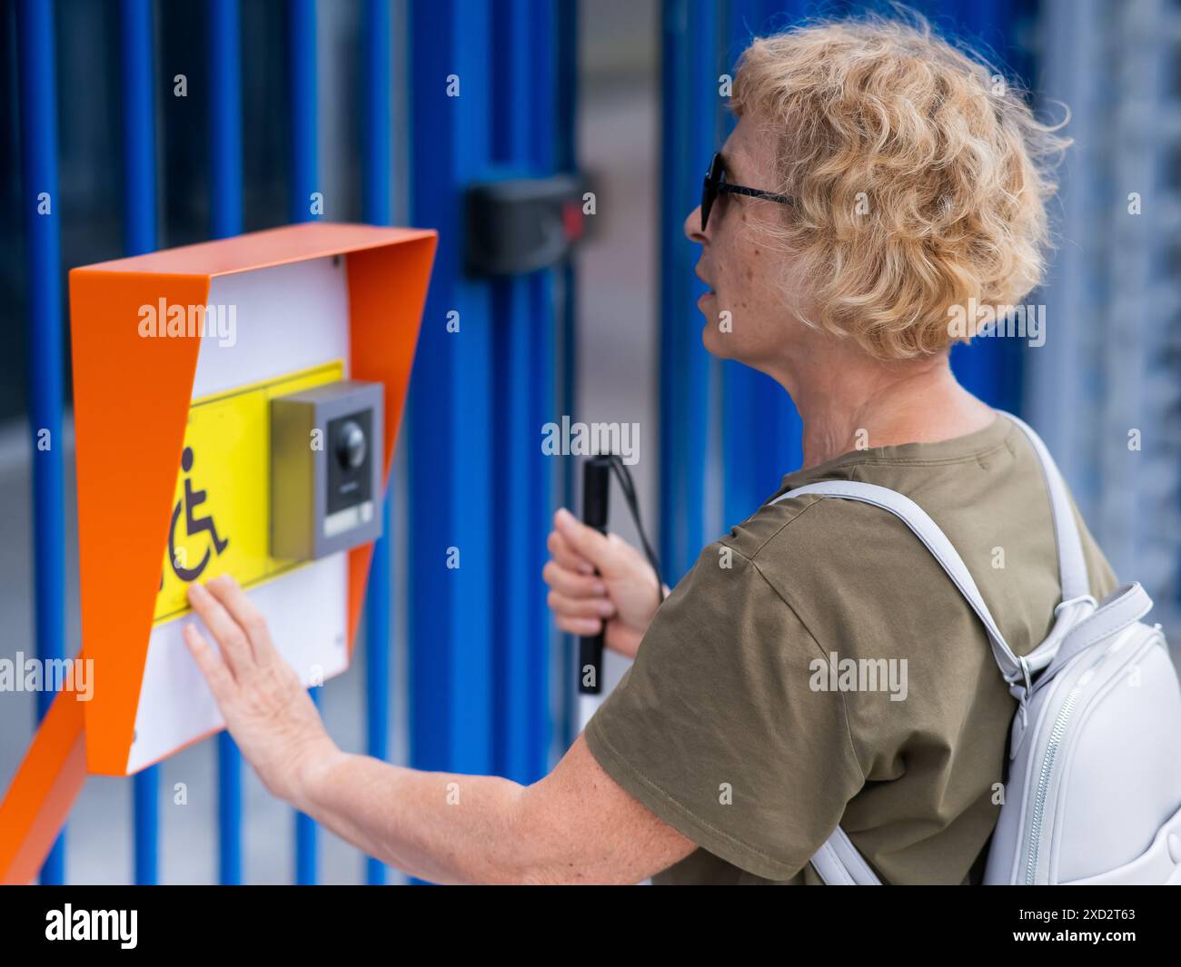 An elderly blind woman reading a text in braille button for calling