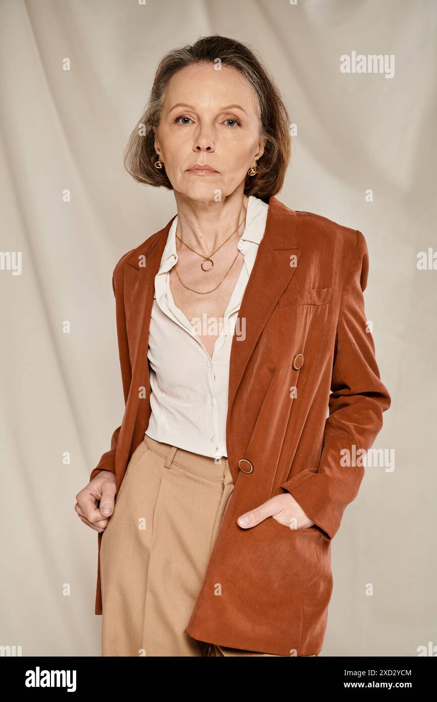 A vibrant woman in an orange blazer and tan pants strikes poses Stock ...