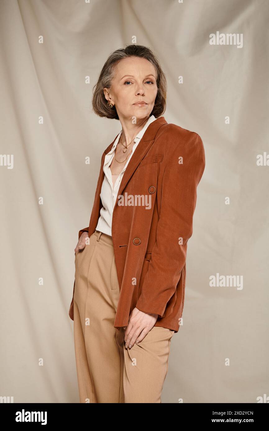 A mature woman in a brown blazer and tan pants, exuding confidence and style, engages in active poses. Stock Photo