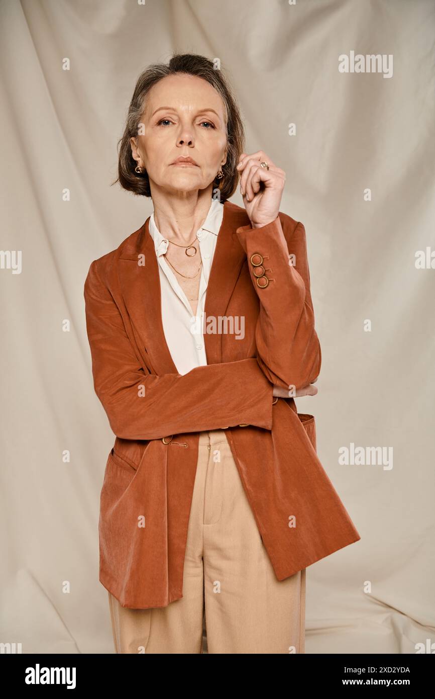 Stylish woman in brown jacket and tan pants striking a pose Stock Photo ...