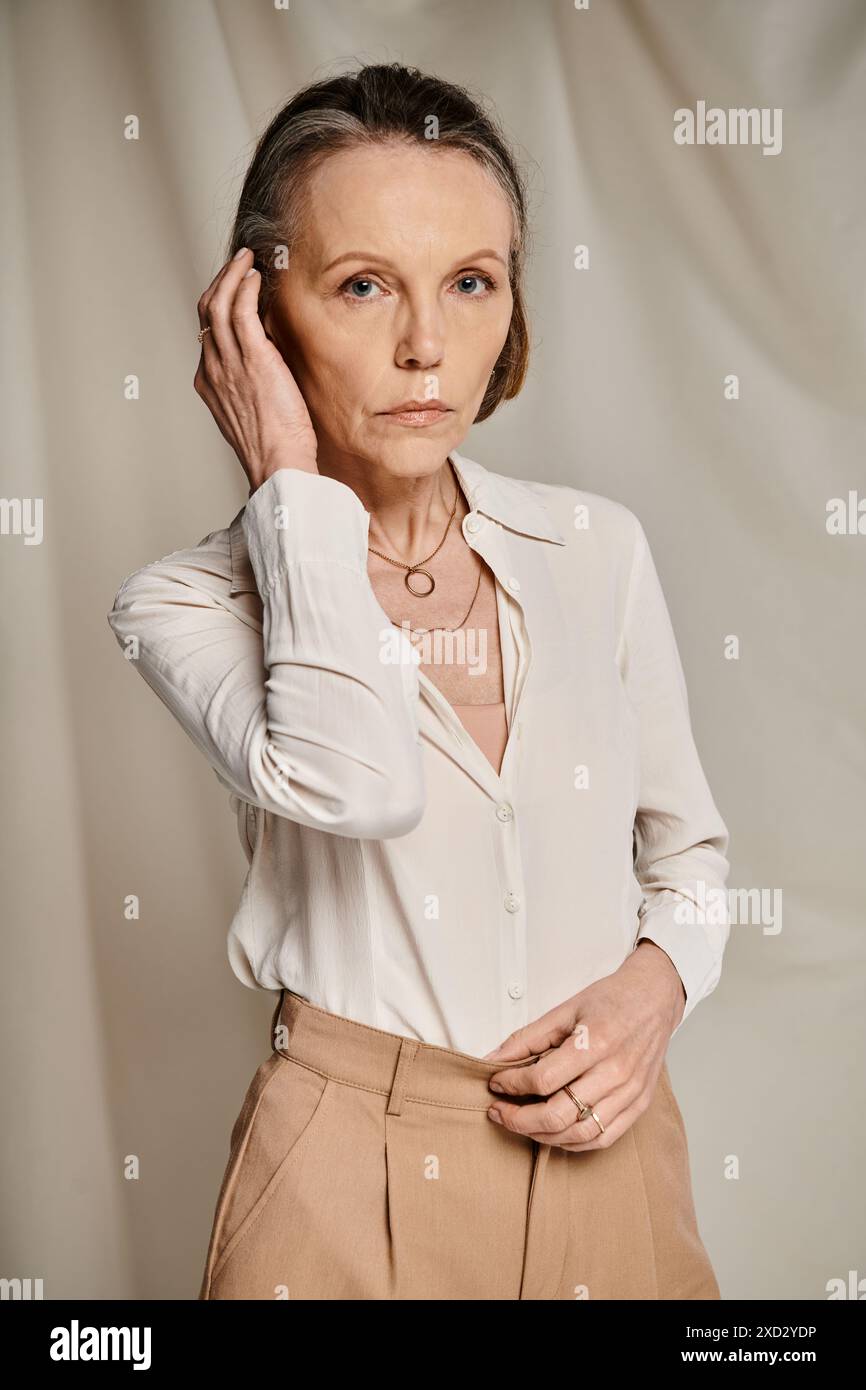 Mature woman in white shirt and tan pants with grace and poise Stock ...