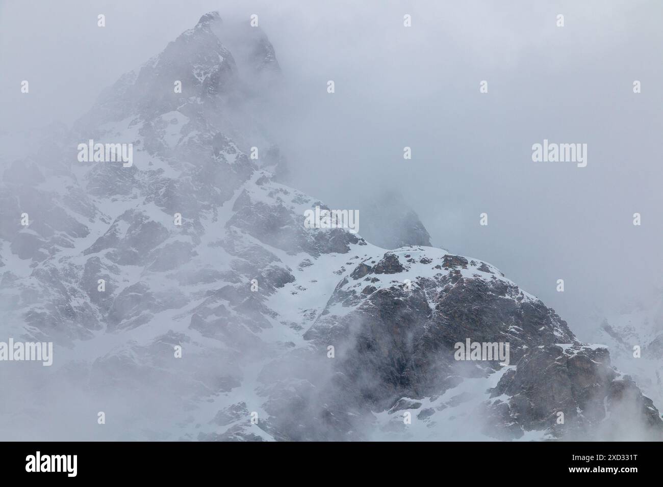 Snowy mountain peaks in clouds Stock Photo