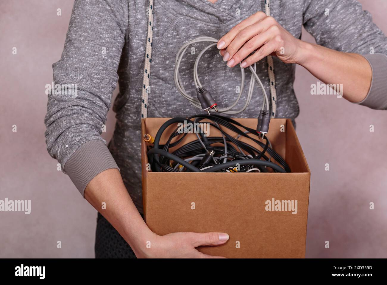Female hands stacking discarded electronic devices in a cardboard box Stock Photo