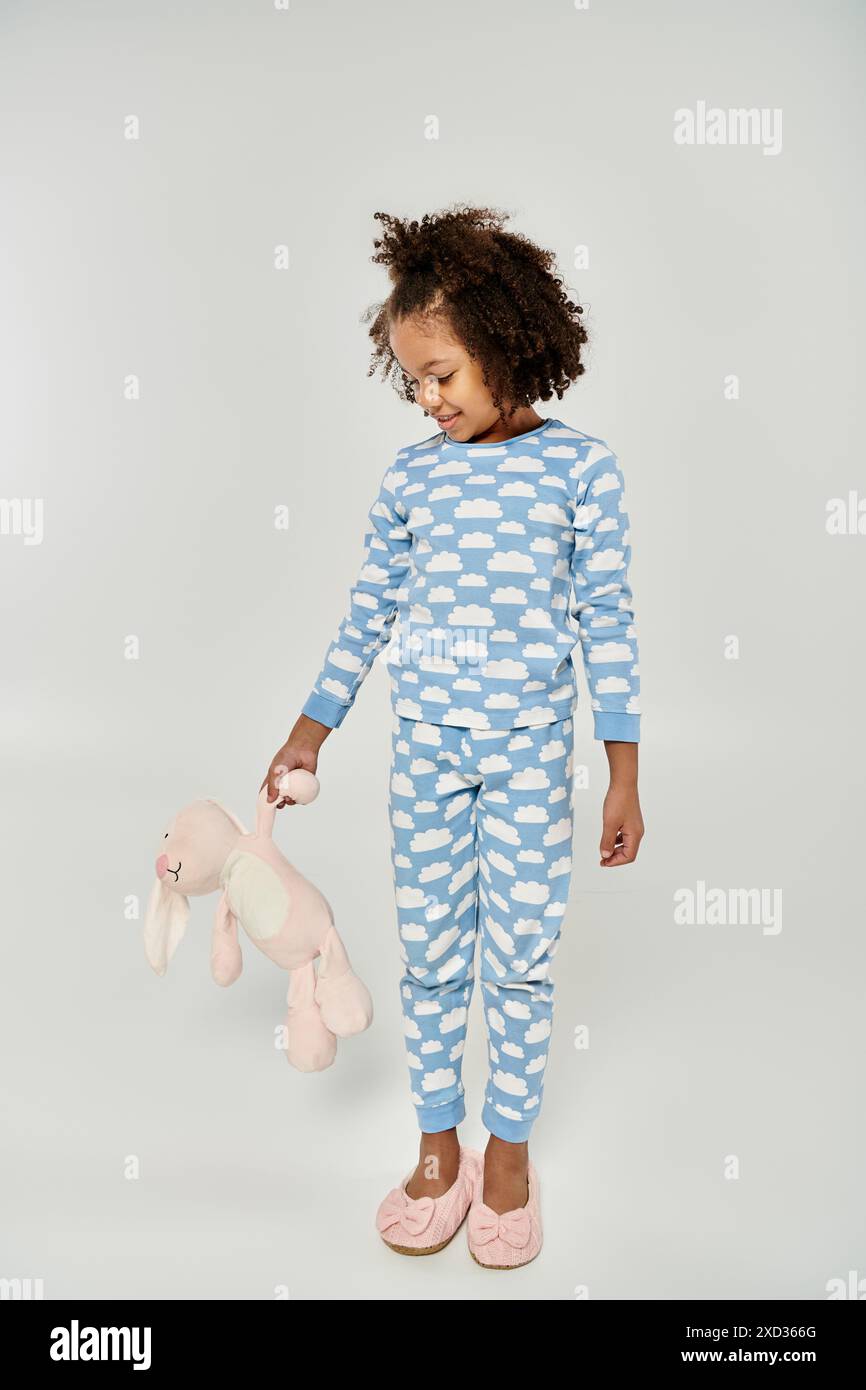 Little girl in blue pajamas cherishes her stuffed teddy bear Stock ...