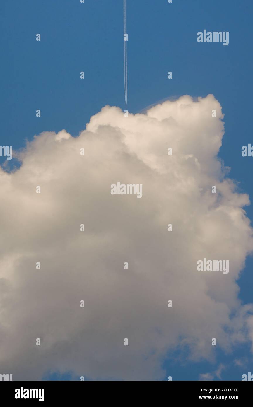 Conceptual Plane flying among white fluffy clouds Stock Photo