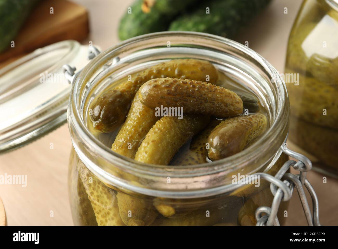 Pickled cucumbers in open jar on table, closeup Stock Photo