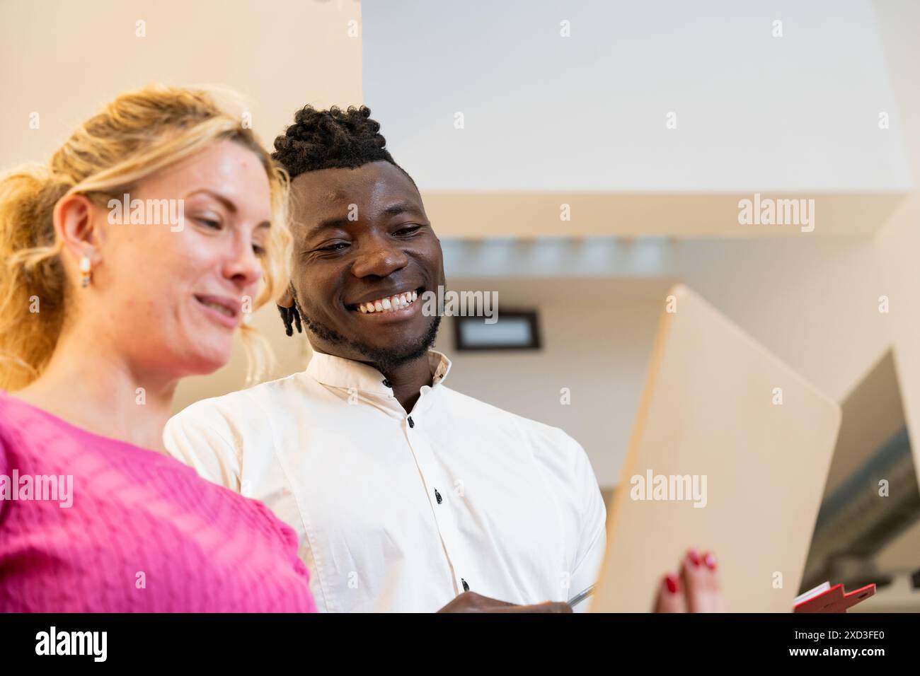 While Viewing Diverse man and woman sharing a cheerful moment while viewing content ...