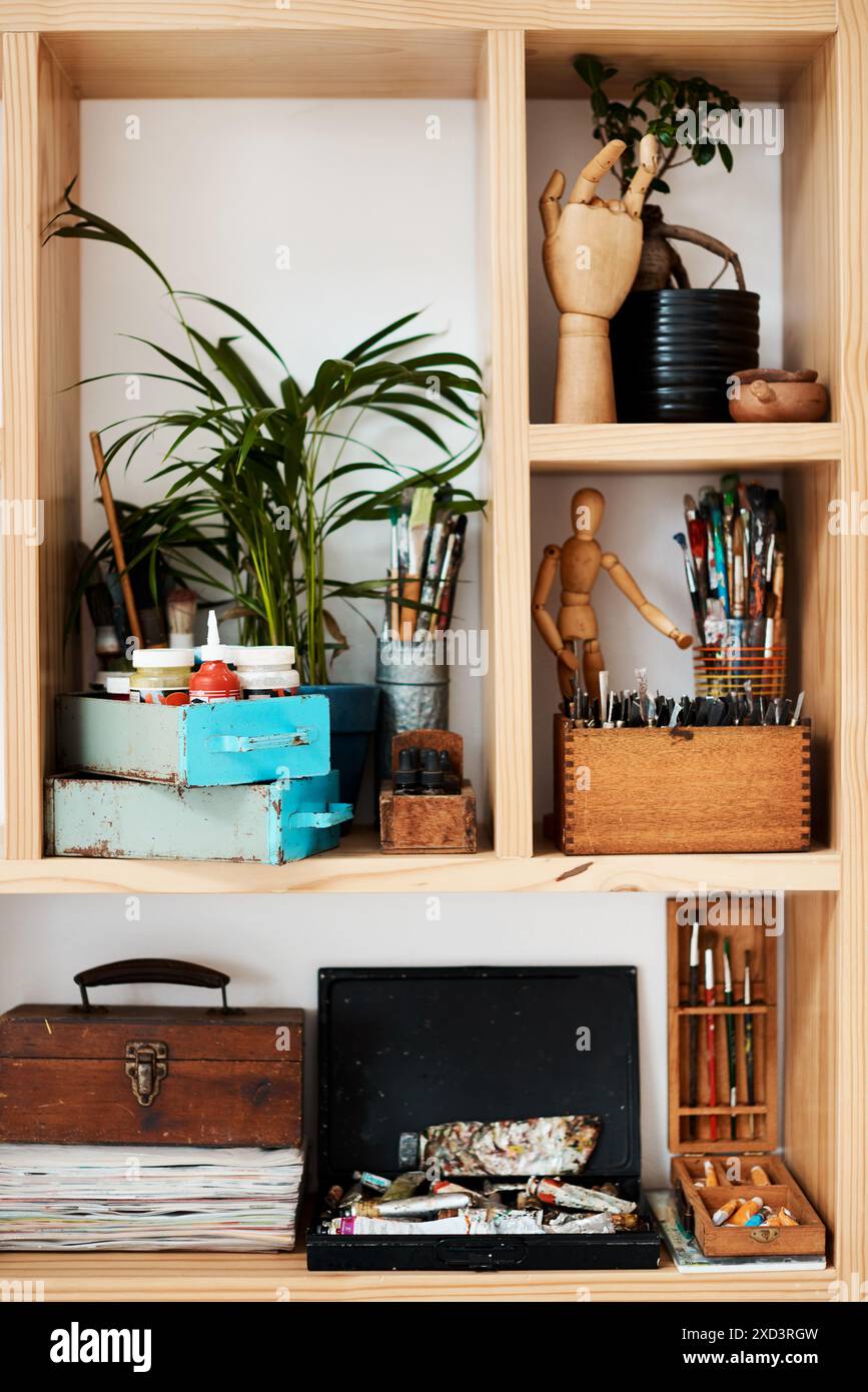 Shelf, equipment and supplies in empty art studio for paint brush, creative or talent showcase. Workshop bookcase and room with tools storage for Stock Photo
