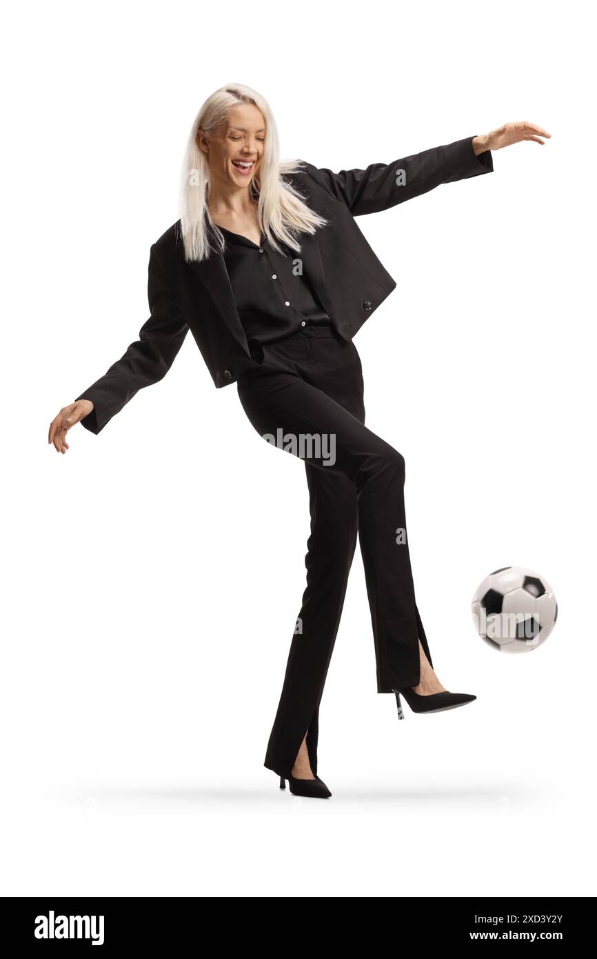 Woman wearing high heels and kicking a football isolated on white background Stock Photo