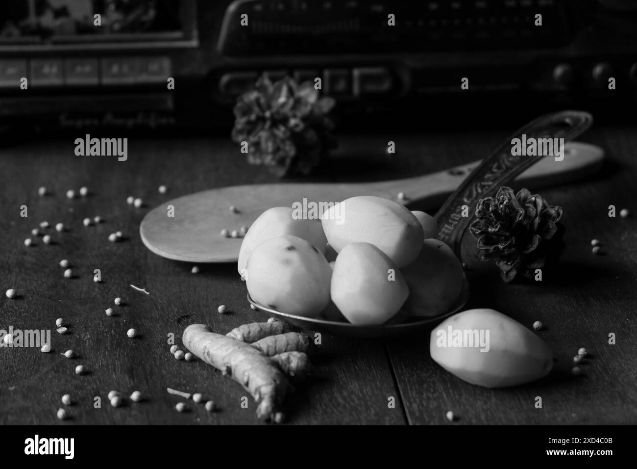 The photo is of kitchen spices in the form of potatoes, turmeric, white pepper against the background of an old radio Stock Photo