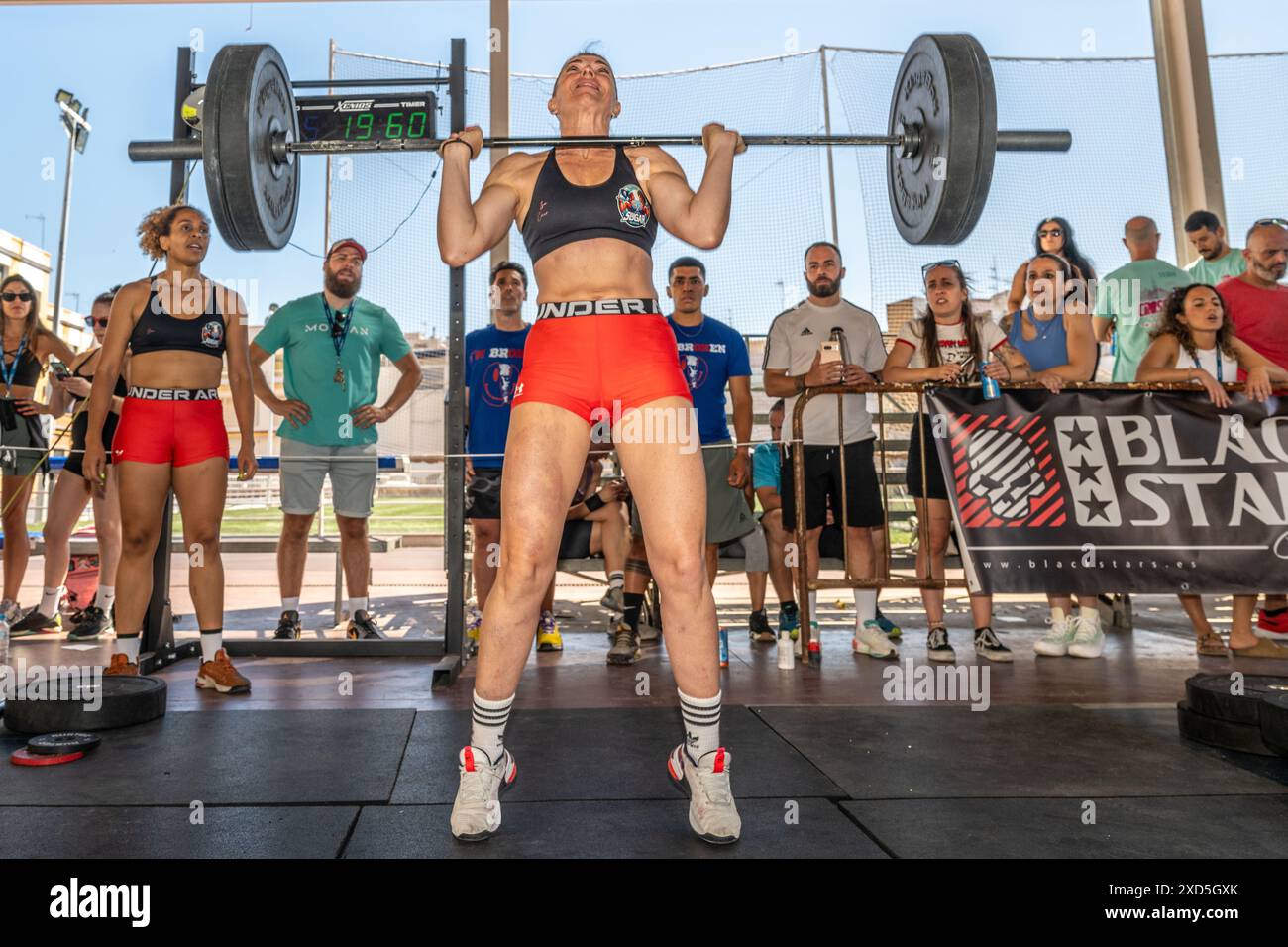 Participants lifting heavy weights during a crossfit competition in ...