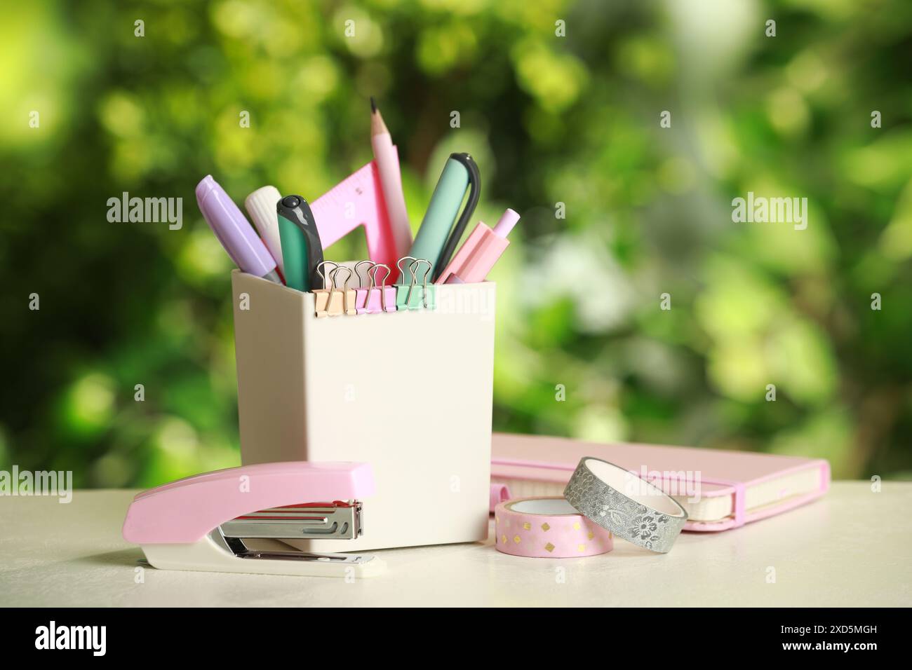 Stapler, holder and other different stationery on white table Stock Photo