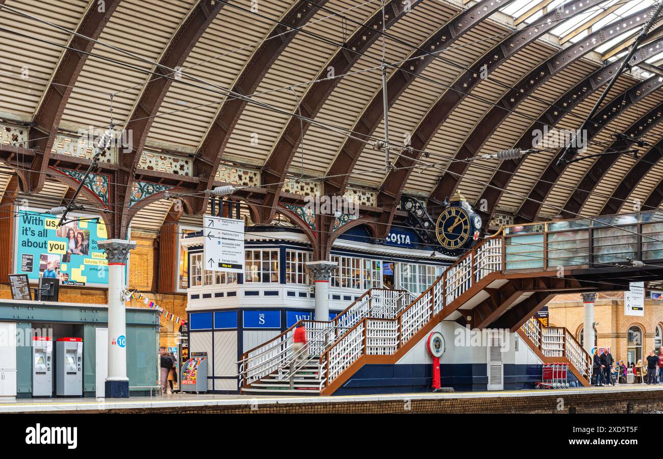 A railway station concourse under a 19th Century iron canopy. A ...