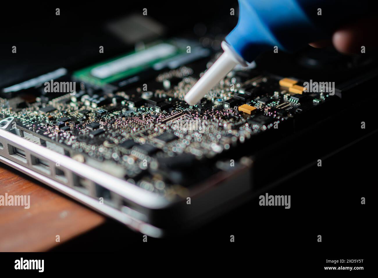 View of Close-up of a person using a blower to clean dust from a laptop's ...
