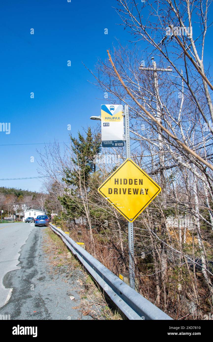 Bus stop and hidden driveway signs on Purcells Cove Road in Fergusons Cove, Nova Scotia, Canada Stock Photo