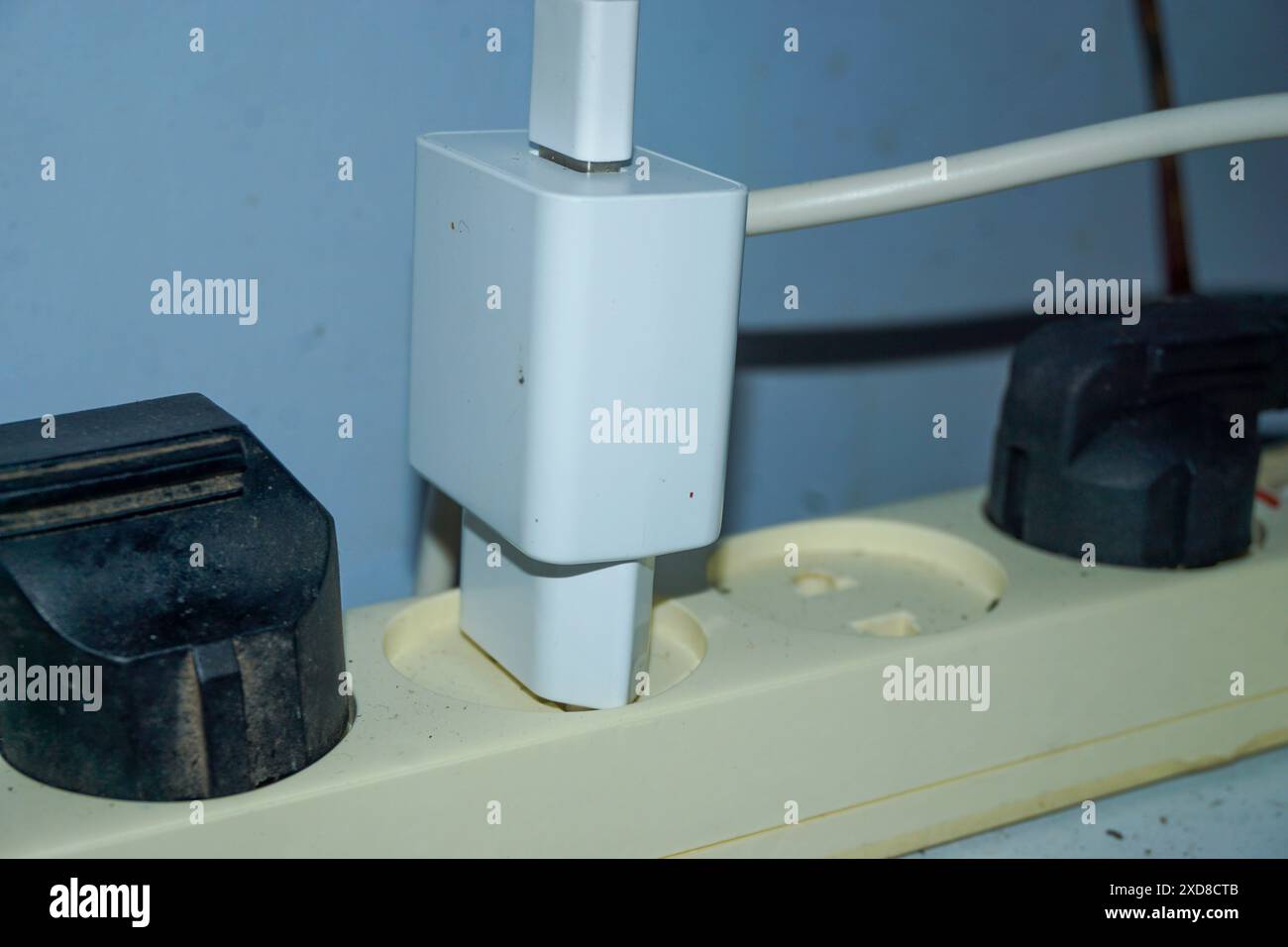 Someone stuck the plug in the socket. someone plugged the phone charger into a wall outlet. High quality photos Stock Photo
