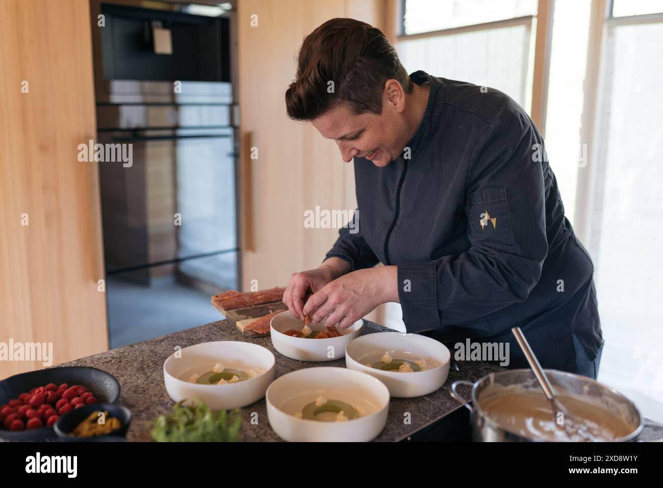 Chef preparing a gourmet dish in a kitchen with fresh ingredients Stock ...