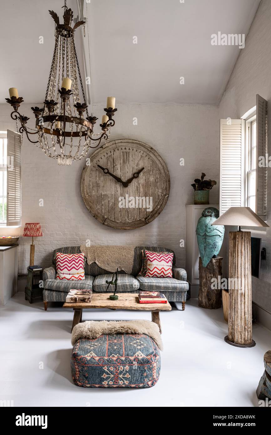 Statement clockface in lofty double height living room in late 19th century Victorian school house, Battersea, London, UK Stock Photo