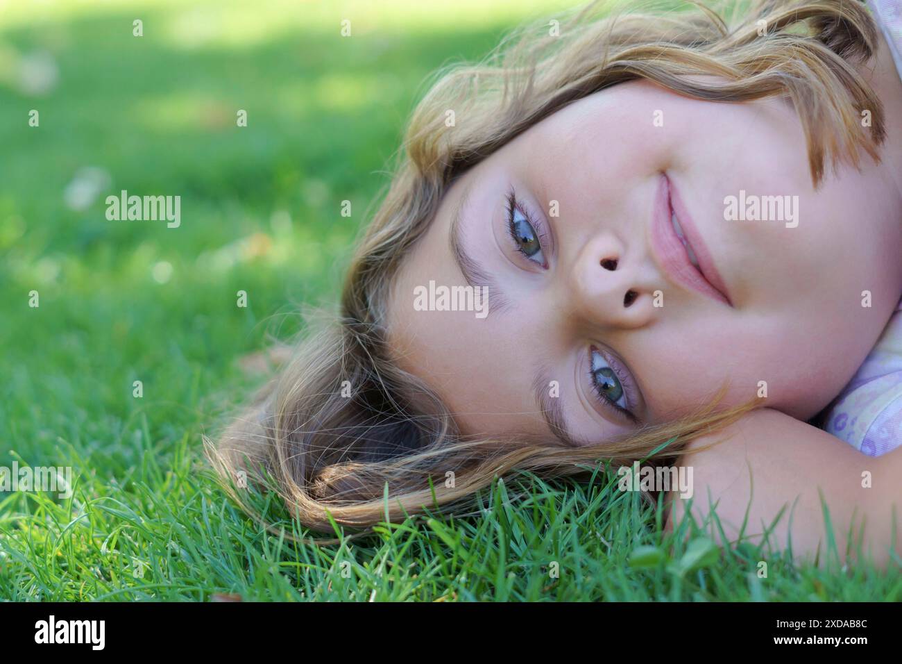Close-up portrait of a pretty blonde girl with long hair and light eyes ...