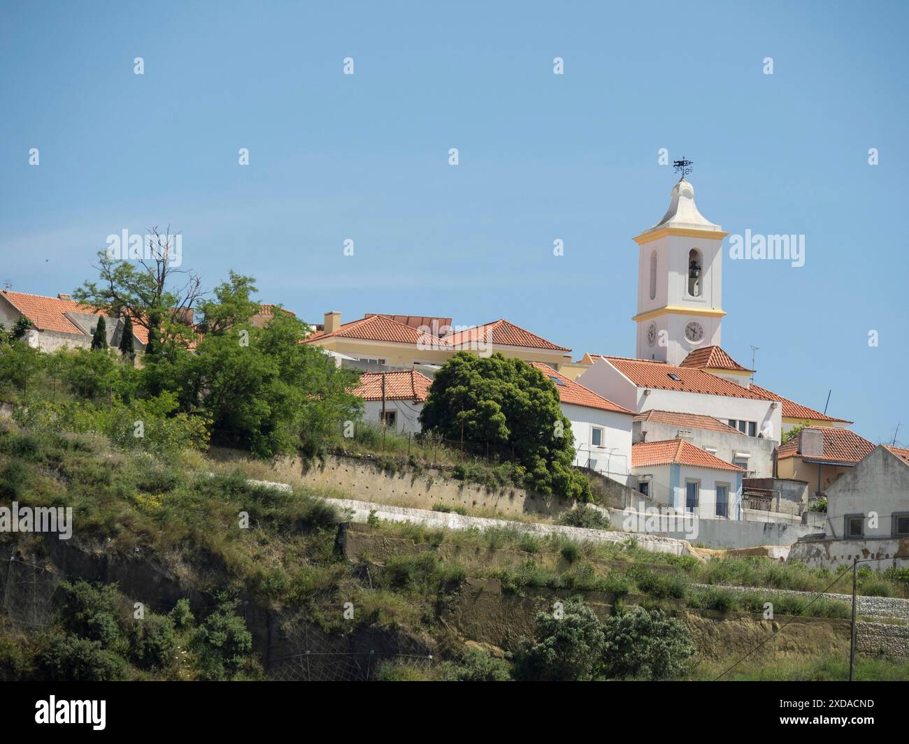 Small village on a hill with traditional architecture and a church under a clear sky, lisbon, portugal Stock Photo