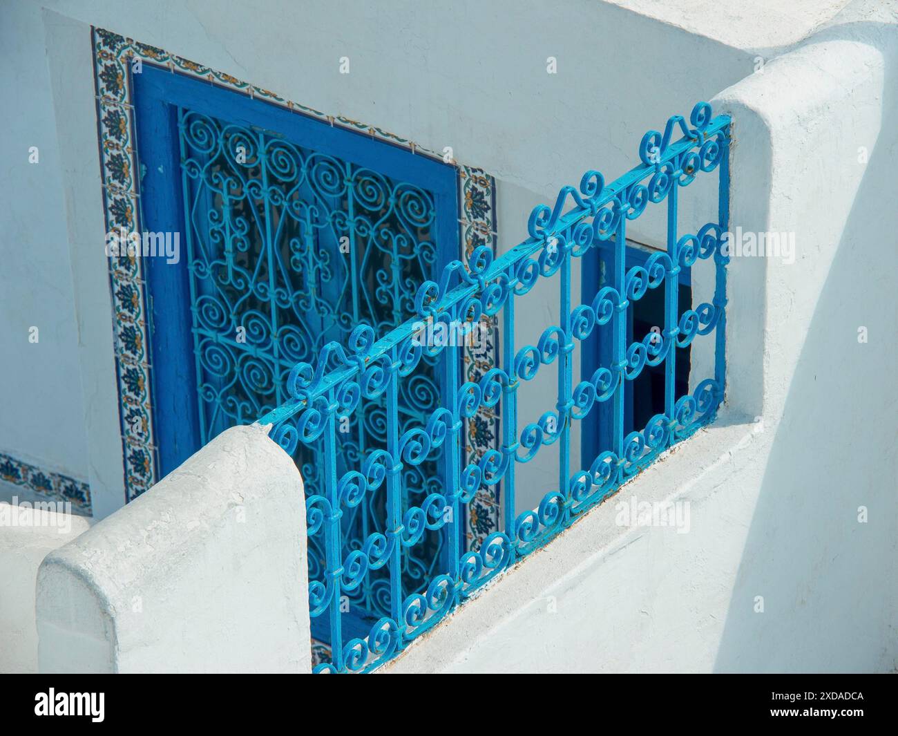 Blue wrought-iron railing and door in front of a white Mediterranean ...