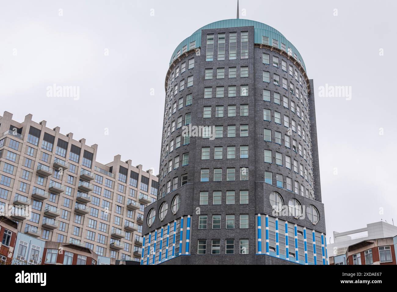 Image of a modern round building with many windows in front of a grey