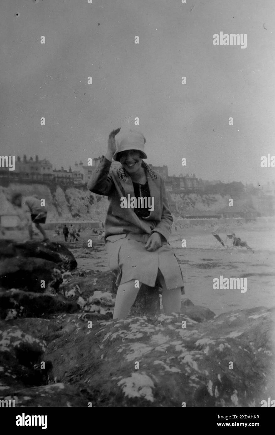 A lady in a hat and coat sitting on a rock at the water’s edge, on a windy June day. Fashion and culture. From a collection of snapshot photographs of a group of women, 1928. There were few annotations on the photos, but the women seemed to travel as a group and clearly had a liking for the English county of Kent. A couple of the photos suggest they may have been feminists of their day and, although they are largely unknown, I have included them as they represent some of the fashions of the time. Stock Photo