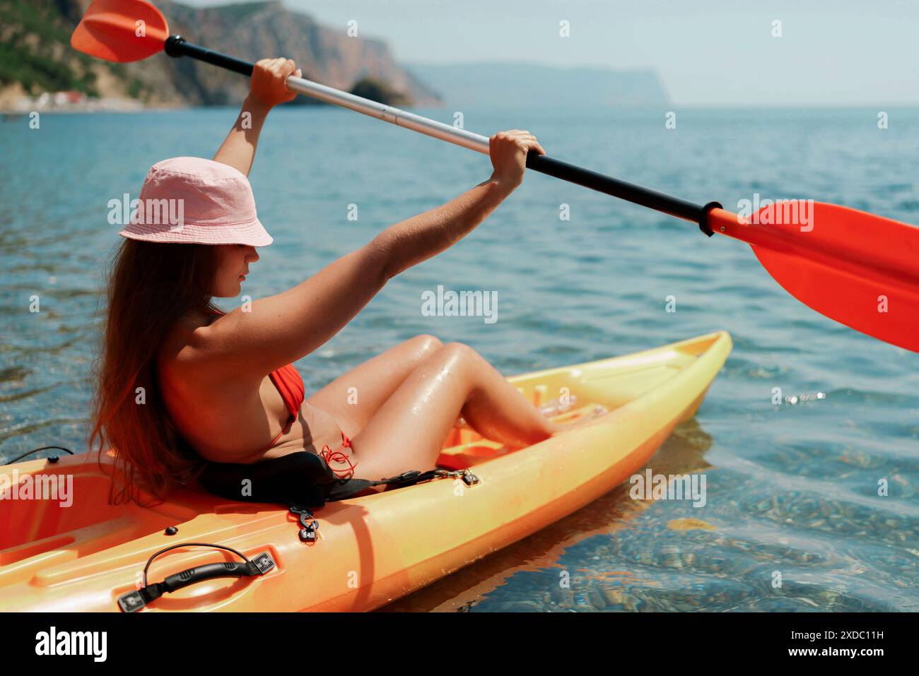 Kayak sea woman. Happy attractive woman with long hair in red swimsuit, swimming on kayak. Summer holiday vacation and travel concept Stock Photo
