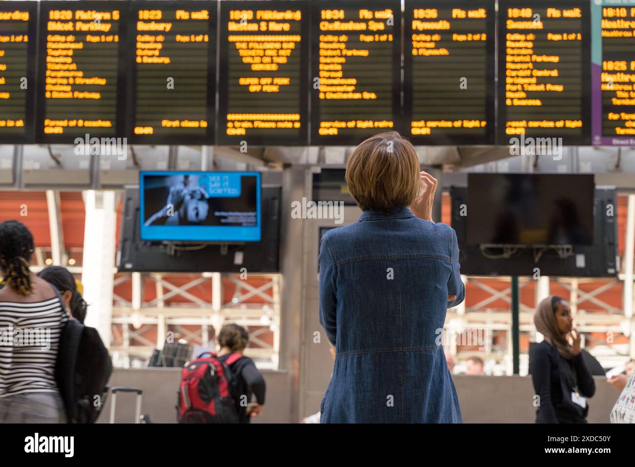London, UK, 121st June 2024. UK Weather: commuter checking the train departure LED boards for their next trains and departure time at London train terminal, starting their mini-heatwave weekend, London England.  Credit: Xiu Bao/Alamy Live News Stock Photo