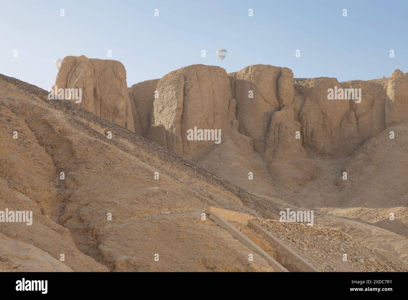 Two hot air balloons rise in the early morning over the sandstone cliffs of the Valley of the Kings, Luxor, Egypt. Stock Photo