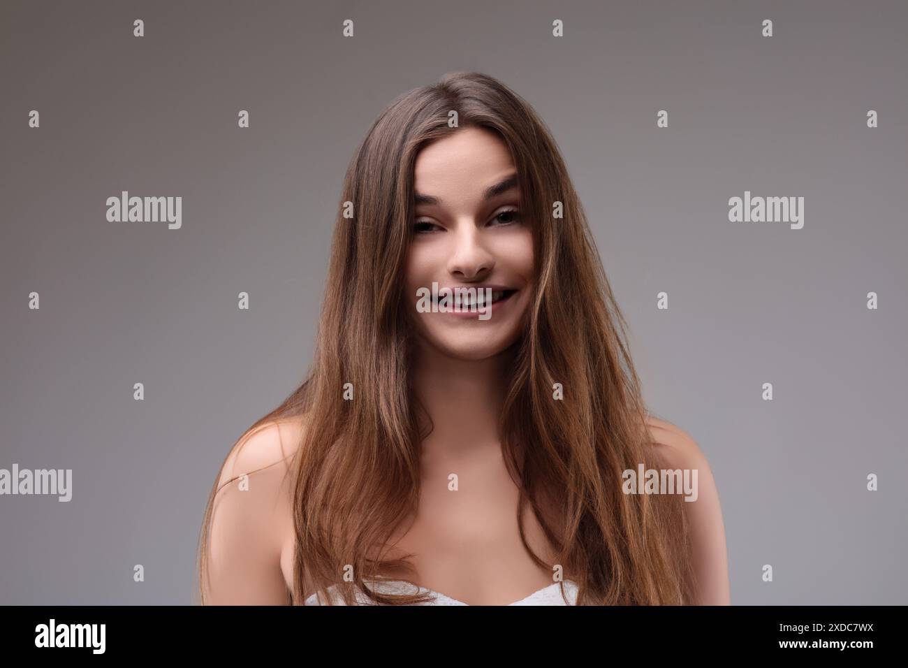 Portrait of a beautiful young woman with long brown hair smiling on a ...