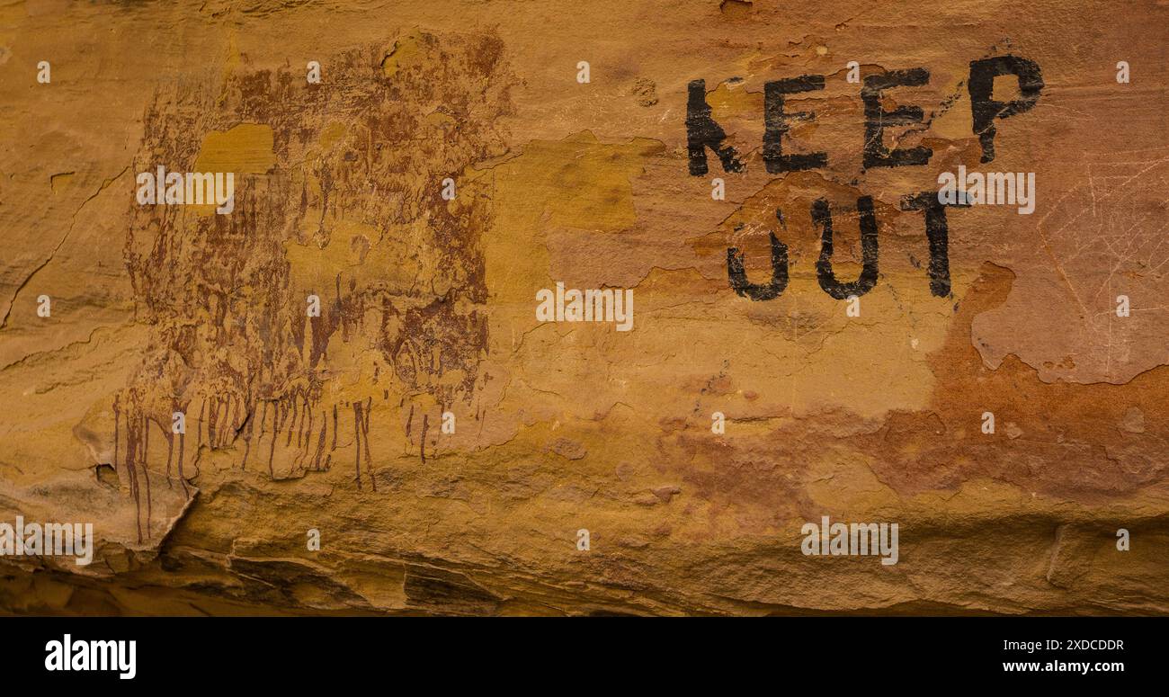 “KEEP OUT.”  Ancient pictograph, otherworldly, mysterious and unknown, defaced by a Utah rancher, warning away visitors in the 1950s. Stock Photo