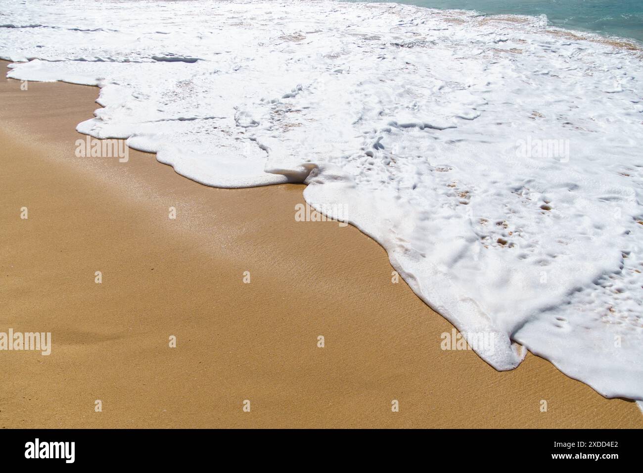 Waves crash on sandy beach under sunny sky, creating beautiful scene ...